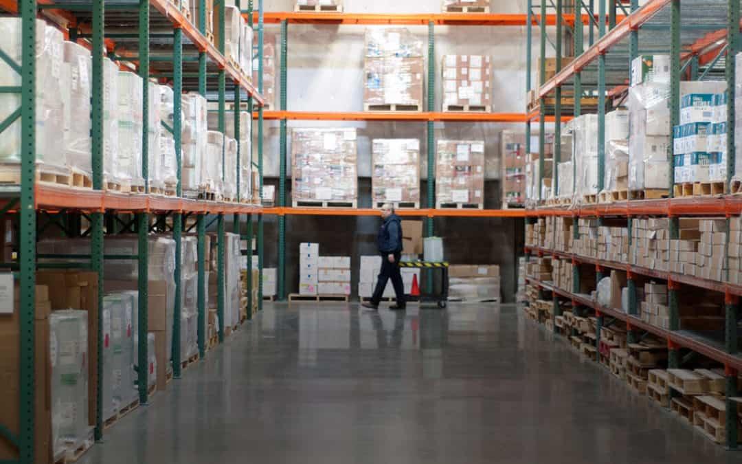 Man walking through warehouse shelves