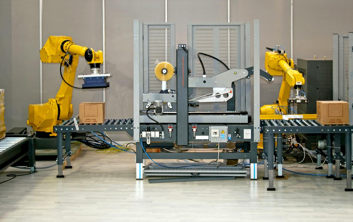 A conveyor of boxes moves quickly as they are assembled, sealed, and then palletized by robotic packaging automation. 