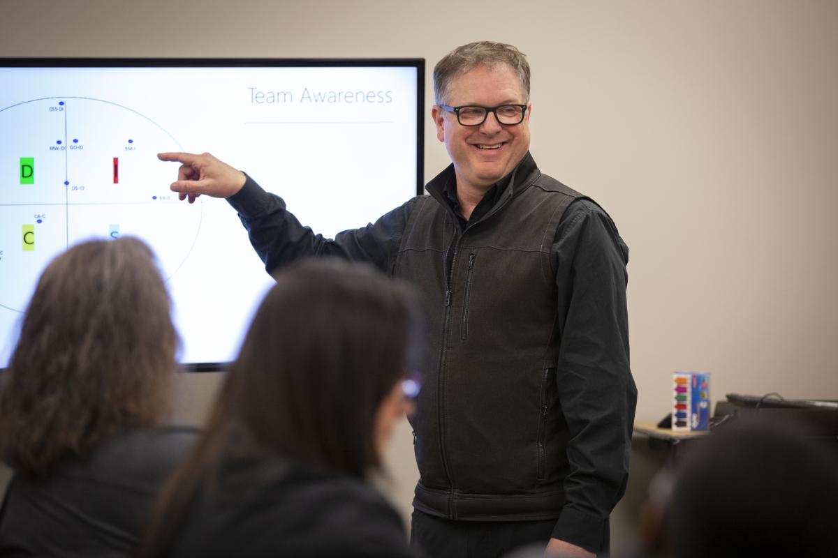 Man giving PowerPoint presentation in front of TV