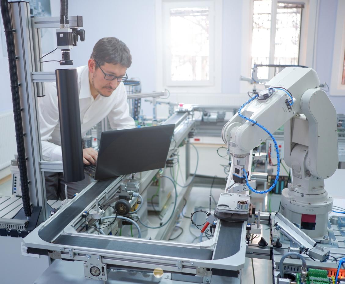 Engineer is working on laptop to programming smart factory automation stock photo